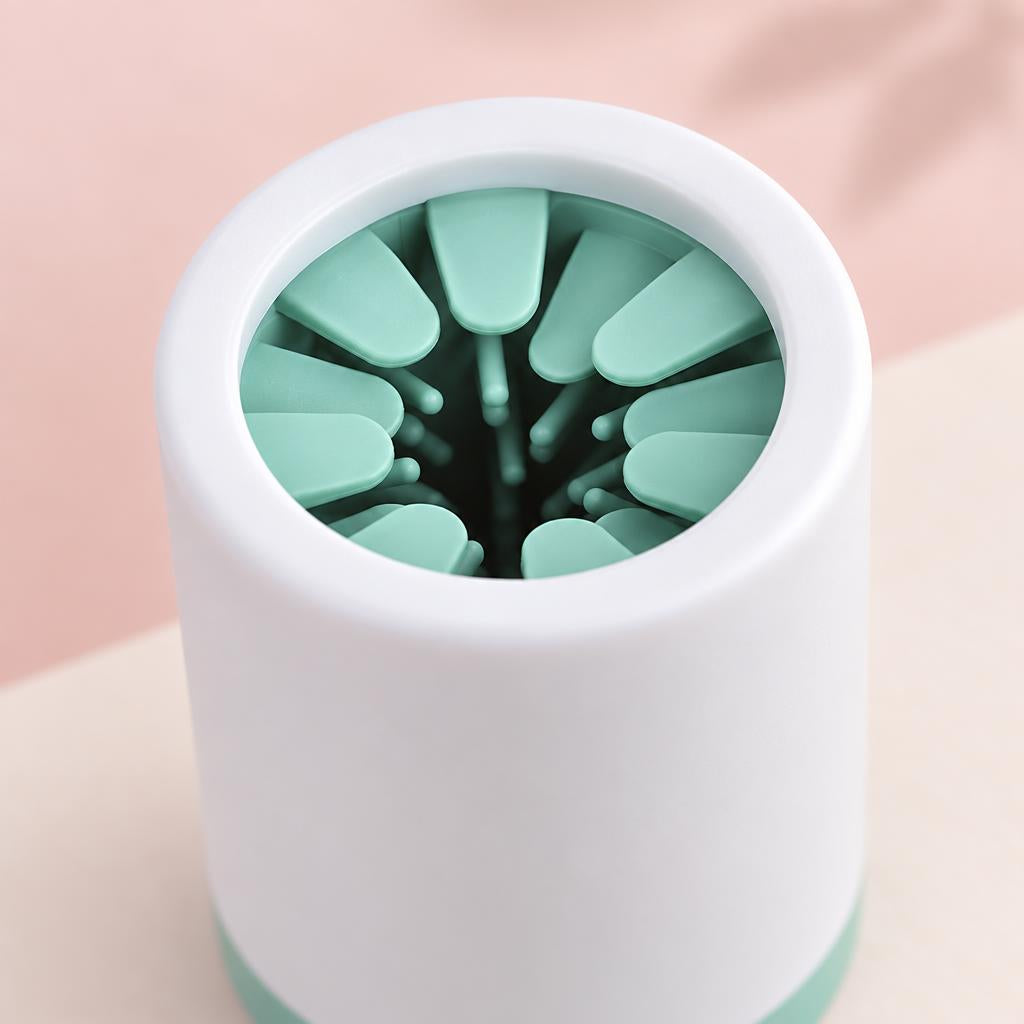 Close-up of the green and white silicone paw cleaner cup on a soft pink background