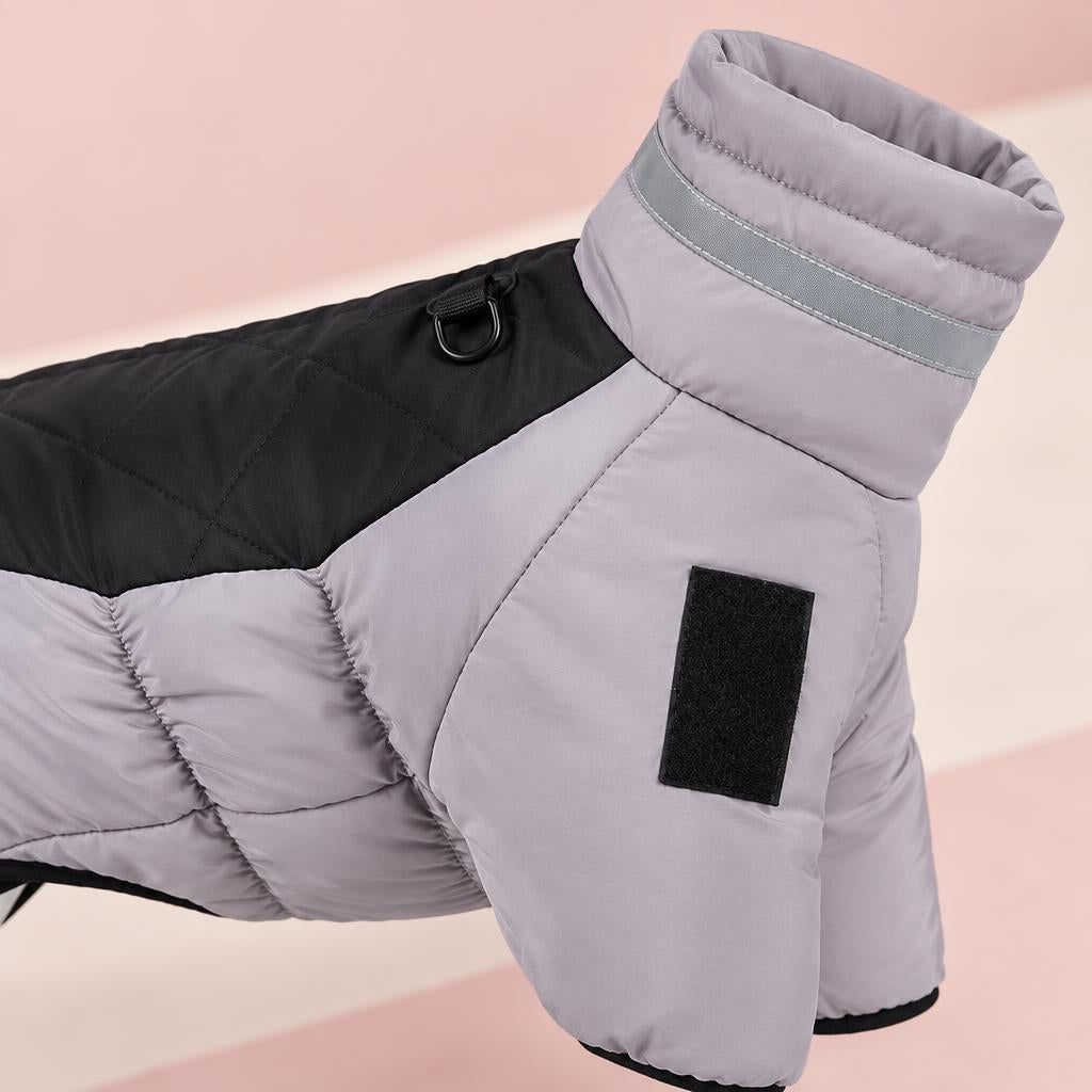 Close-up of the grey and black padded winter dog coat with a high collar on a soft pink background