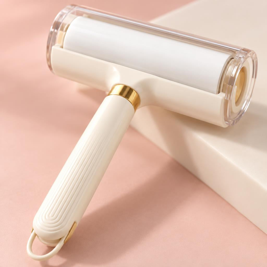 Close-up of the cream roller head with a clear guard and the gold ring at the top of the handle, on a soft pink background