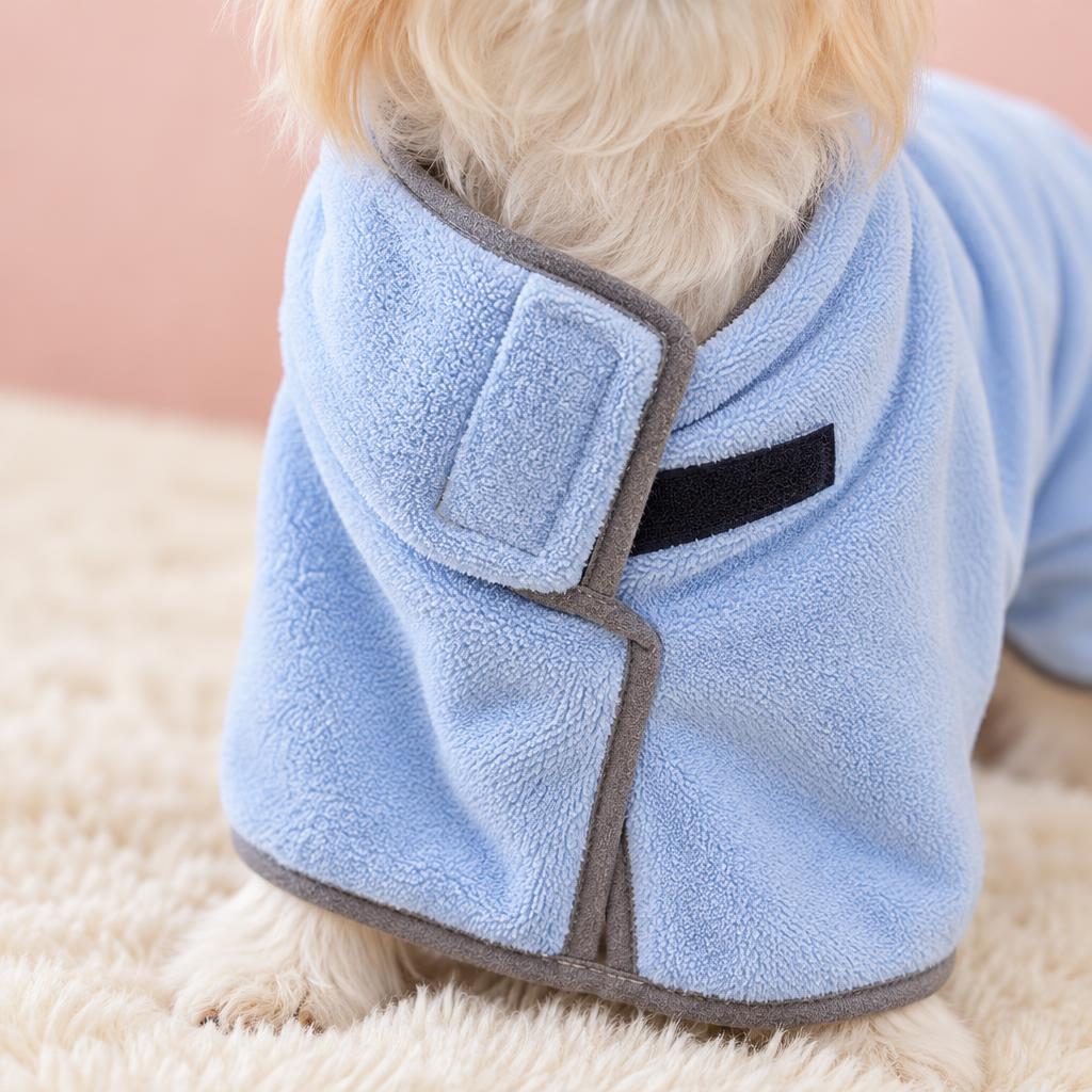 Close-up of the quick-drying blue towel robe for dogs on a soft pink background
