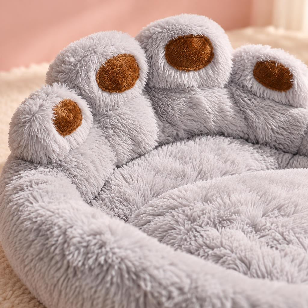 Close-up of the raised paw pads and plush grey fur of the paw-shaped pet bed